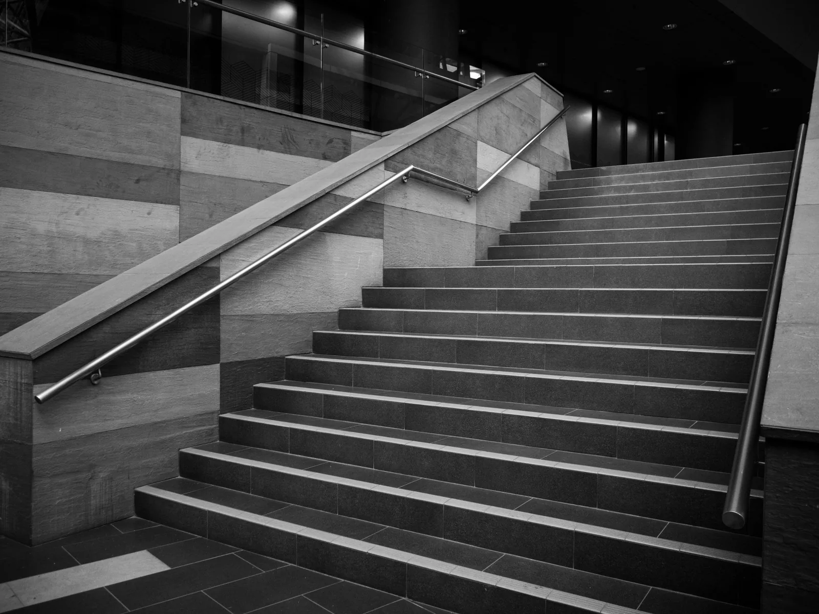 A wide stone staircase rising through a dark hall
